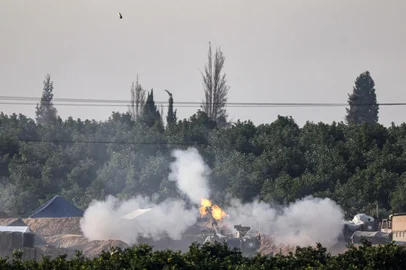 A picture taken from southern Israel near the border with the Gaza Strip on December 4, 2023, shows an Israeli tank firing towards the Palestinian territory amid continuing battles between Israel and the militant group Hamas. Israel has expanded its ground war on Hamas into the south of Gaza, witnesses said on December 4, despite global concern over mounting civilian deaths and fears the conflict will spread elsewhere in the Middle East. (Photo by JACK GUEZ / AFP)Editoria: WARLocal: Israel-Gaza BorderIndexador: JACK GUEZSecao: armed conflictFonte: AFPFotógrafo: STF<!-- NICAID(15615882) -->