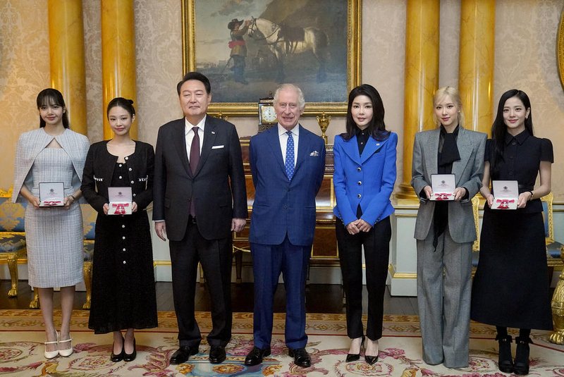 Britain's King Charles III (C) stands with South Korea's President Yoon Suk Yeol (3L), South Korea's First Lady Kim Keon Hee (3R), and K-Pop band Blackpink's members, from left, Lalisa Manoban, Jennie Kim, Roseanne Park and Jisoo Kim following aspecial investiture ceremony to present the band's members with Honorary MBEs (Member of the Order of the British Empire), at Buckingham Palace in London on November 22, 2023, on the second day of the President's three-day state visit to the UK. (Photo by Victoria Jones / POOL / AFP)<!-- NICAID(15606208) -->