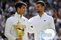 Spain's Carlos Alcaraz holding the winner's trophy (L) is congratulated by Serbia's Novak Djokovic as they pose for pictures during the price ceremony at the end of their men's singles final tennis match on the fourteenth day of the 2024 Wimbledon Championships at The All England Lawn Tennis and Croquet Club in Wimbledon, southwest London, on July 14, 2024. Defending champion Alcaraz beat seven-time winner Novak Djokovic in a blockbuster final, with Alcaraz winning 6-2, 6-2, 7-6. (Photo by ANDREJ ISAKOVIC / AFP) / RESTRICTED TO EDITORIAL USE<!-- NICAID(15814053) -->