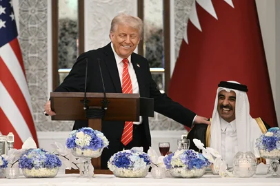 US President Donald Trump (L) speaks with Qatar's Emir Sheikh Tamim bin Hamad al-Thani at the start of a state dinner at the Lusail Palace in Doha on May 14, 2025. (Photo by Brendan SMIALOWSKI / AFP)<!-- NICAID(16038171) -->