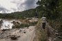 A man walks along the partially collapsed RN25 road in Ranomafana on February 7, 2022 following the passage of cyclone Batsirai. - Cyclone Batsirai swept out of Madagascar on Monday after killing 20 people, displacing 55,000 and devastating the drought-hit island's agricultural heartland, leading the UN to warn of a worsening humanitarian crisis. (Photo by RIJASOLO / AFP)Editoria: WEALocal: RanomafanaIndexador: RIJASOLOSecao: floodFonte: AFPFotógrafo: STR<!-- NICAID(15010695) -->