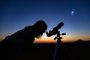 Woman looking at night sky with amateur astronomical telescope.Fonte: 398404157<!-- NICAID(15162468) -->