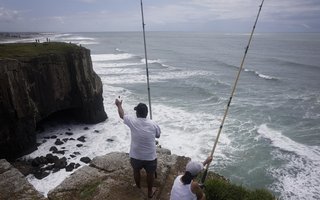 TORRES, RS, BRASIL, 22-01-2026: O pescador Osvaldino Teixeira, conhecido como "Vardo", pesca com a esposa, Fátima Teixeira, no costão no Morro das Furnas, em Torres. Foto: Mateus Bruxel/Agência RBSIndexador: MATEUS BRUXEL<!-- NICAID(16209504) -->