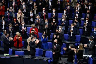 Designated German Chancellor Olaf Scholz (first row, C) is applauded after he was elected as the country's next Chancellor during a session at the Bundestag (lower house of parliament) in Berlin on December 8, 2021. - Members of the parliament elected Olaf Scholz, bringing the curtain down on Angela Merkel's 16-year reign, ushering in a new political era with the centre-left in charge. Together with the Greens and the liberal Free Democrats, Scholz's SPD managed in a far shorter time than expected to forge a coalition that aspires to make Germany greener and fairer. (Photo by Ina Fassbender / AFP)<!-- NICAID(14962338) -->