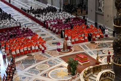 This photo taken and released on April 23, 2025, by The Vatican Media shows Irish-born US Cardinal Kevin Joseph Farrell (cc) standing to pay his respects next to the coffin of late Pope Francis during the ceremony at St Peter's basilica following the procession of the late Pope's coffin from the chapel of Santa Marta to St Peter's Basilica, in The Vatican.