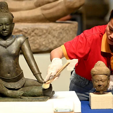 A worker cleans Budhisattva Avalokiteshvara, a copper alloy sculpture with silver inlay from the 10th-early 11th century Angkor period, during a repatriation event for Angkorian artefacts returned from the United States at the National Museum in Phnom Penh on July 4, 2024. Buddhist monks in the Cambodian capital Phnom Penh chanted blessings and threw flowers on July 4 in a welcoming ceremony for 14 trafficked artefacts that were repatriated by a prestigious New York museum. (Photo by TANG CHHIN SOTHY / AFP)Editoria: SCILocal: Phnom PenhIndexador: TANG CHHIN SOTHYSecao: human scienceFonte: AFPFotógrafo: STF<!-- NICAID(15806061) -->