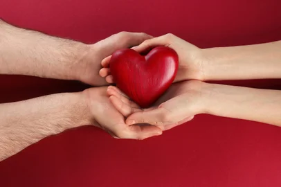 Couple holding decorative heart on color background, top viewFonte: 273553310<!-- NICAID(15142281) -->
