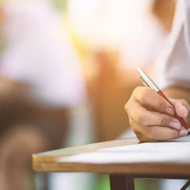Closeup to hand of student  holding pen and taking exam in classroom with stress for education test . arrowsmith2 / stock.adobe.com<!-- NICAID(15749505) -->