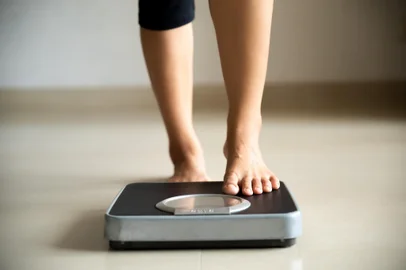 Female leg stepping on weigh scales. Healthy lifestyle, food and sport concept.<!-- NICAID(15671252) -->