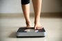 Female leg stepping on weigh scales. Healthy lifestyle, food and sport concept.<!-- NICAID(15671252) -->
