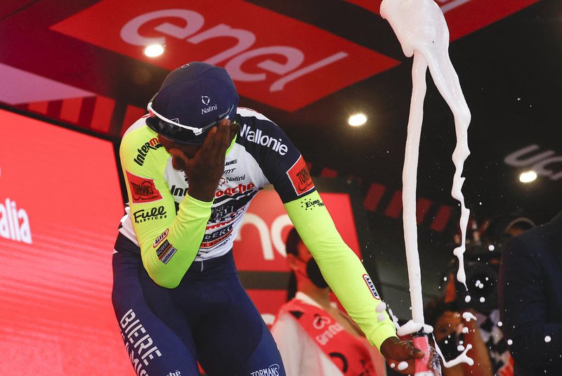 Team Wanty's Eritrean rider Biniam Girmay Hailu reacts after popping a champagne cork as he celebrates on the podium after winning the 10th stage of the Giro d'Italia 2022 cycling race, 196 kilometers between Pescara and Jesi, central Italy, on May 17, 2022. - History-maker Biniam Girmay pulled out of the Giro d'Italia before the start of the 11th stage, with an eye injury he suffered when he was struck by a champagne cork. (Photo by Luca Bettini / AFP)Editoria: SPOLocal: JesiIndexador: LUCA BETTINISecao: cyclingFonte: AFPFotógrafo: STR<!-- NICAID(15099081) -->