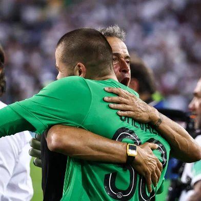 Paris Saint-Germain's Spanish headcoach Luis Enrique (C) embraces Paris Saint-Germain's French goalkeeper #30 Lucas Chevalier (R) as they celebrate winning the 2025 UEFA Super Cup final football match between Paris Saint-Germain (FRA) and Tottenham Hotspur FC (ENG) at the Friuli stadium, in Udine, on August 13, 2025. (Photo by FRANCK FIFE / AFP)<!-- NICAID(16100953) -->