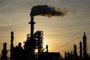 (FILES) The sun sets behind smoke rising from the LyondellBasell-Houston Refining plant in Houston, Texas, on April 20, 2020. An escalation of the war between Israel and Hamas could further strain global oil and gas supplies, already disrupted by Russia's invasion of Ukraine, experts warn. (Photo by Mark Felix / AFP)<!-- NICAID(15582170) -->