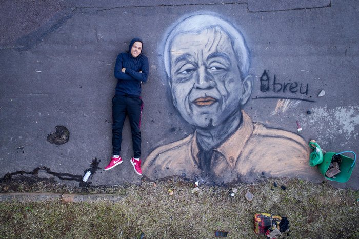 Criador e criatura: artista deita no chão e deixa sua assinatura registrada. A letra