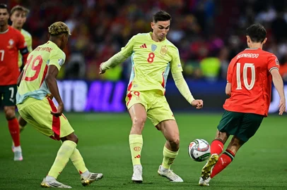 Portugal's midfielder #10 Bernardo Silva (R) and Spain's midfielder #08 Fabian Ruiz (C) vie for the ball during the UEFA Nations League final football match between Portugal and Spain in Munich, southern Germany on June 8, 2025. (Photo by Tobias SCHWARZ / AFP)<!-- NICAID(16055093) -->