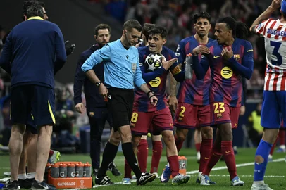 Barcelona players argue after the referee gave a red card to Barcelona's Spanish defender #24 Eric Garcia  during the UEFA Champions League quarter final second leg football match between Club Atletico de Madrid and FC Barcelona at Metropolitano Stadium in Madrid on April 14, 2026. (Photo by Javier SORIANO / AFP)<!-- NICAID(16265916) -->