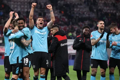 Bayer Leverkusen's players celebrate after the German first division Bundesliga football match between RB Leipzig and Bayer Leverkusen in Leipzig on January 20, 2024. (Photo by Ronny HARTMANN / AFP) / DFL REGULATIONS PROHIBIT ANY USE OF PHOTOGRAPHS AS IMAGE SEQUENCES AND/OR QUASI-VIDEOEditoria: SPOLocal: LeipzigIndexador: RONNY HARTMANNSecao: soccerFonte: AFPFotógrafo: STR<!-- NICAID(15661648) -->