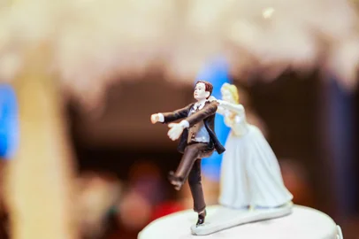groom doll and statue is running away but bride can catch him finally. the funny wedding story doll on the top of cake.Bolo de casamento - Foto: Surachetsh/stock.adobe.comFonte: 285289138<!-- NICAID(15335959) -->
