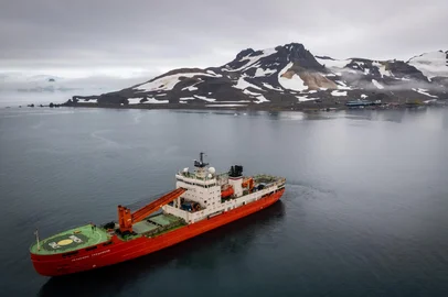 O navio quebra-gelo de pesquisa Akademik Tryoshnikov, ao fundo a estação antártica brasileira em 23 de janeiro:<!-- NICAID(15960877) -->