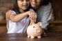 Close up mother and daughter putting coin into piggy bankClose up smiling mother and little daughter hugging, putting coin into pink piggy bank, caring mum teaching adorable girl child to saving money for future, insurance and investment concept - Foto: fizkes/stock.adobe.comFonte: 409576250<!-- NICAID(15234757) -->