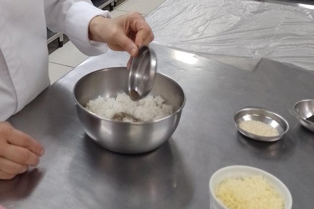 Coloque o arroz triturado em um pote, adicione o queijo ralado, o sal e a pimenta do reino a gosto e misture bem.<!-- NICAID(15123020) -->