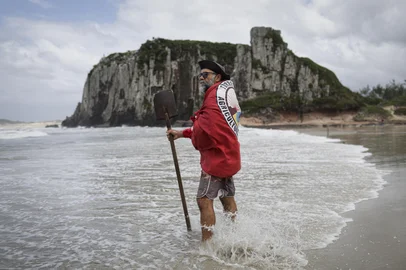 TORRES, RS, BRASIL, 19-01-2026: O artista e ativista ambiental Paulo França, 60 anos, na Praia da Guarita, em Torres, onde cria mandalas gigantes na areia como parte de seu projeto Preserve Torres. Há 30 anos, ele utiliza a land art para chamar atenção para a preservação da natureza, transformando a paisagem costeira em mensagem efêmera contra o lixo e a degradação ambiental. Foto: Mateus Bruxel/Agência RBSIndexador: MATEUS BRUXEL<!-- NICAID(16206578) -->