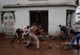 Mesmo com chuva, moradores e voluntários tentam remover lama das ruas de Muçum