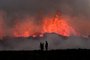 People watch flowing lava during an volcanic eruption near Litli Hrutur, south-west of Reykjavik in Iceland on July 10, 2023. A volcanic eruption started on July 10, 2023 around 30 kilometres (19 miles) from Iceland's capital Reykjavik, the country's meteorological office said, marking the third time in two years that lava has gushed out in the area. "The eruption is taking place in a small depression just north of Litli Hrutur, from which smoke is escaping in a north-westerly direction," the office said. Footage circulating in the local media shows a massive cloud of smoke rising from the ground as well as a substantial flow of lava. (Photo by Kristinn Magnusson / AFP) / Iceland OUTEditoria: DISLocal: Litli-HruturIndexador: KRISTINN MAGNUSSONSecao: volcanic eruptionFonte: AFPFotógrafo: STR<!-- NICAID(15479248) -->