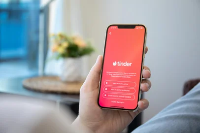 Alanya, Turkey - December 6, 2020: Man hands holding iPhone 12 Pro Max Gold with online Internet network service Tinder on the screen.Indexador: DENYS PRYKHODOVFonte: 399226251<!-- NICAID(15907042) -->