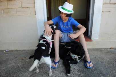 ANTÔNIO PRADO, RS, BRASIL, 11/01/2022 - Thiago do Val Sidegum, 11 anos, é conhecido como "o guri do chapéu", chamou a atenção do mundo ao dar banho, perfumar e enfeitar cachorros abandonados para ficarem com melhor aspecto, e chamassem a atenção de adotantes. Ele conta com a ajuda do pai, Eduardo Sidegum, e outros parceiros que doam shampoos, laços e lenços para os pets. NAS FOTOS: Eduardo e o pai com as cachorras Shiva (preta), Pedrita (malhada), e o gato Félix, todos tirados da rua. (Marcelo Casagrande/Agência RBS)<!-- NICAID(14987398) -->