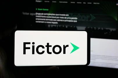 Stuttgart, Germany - 11-28-2025: Person holding smartphone with logo of Brazilian conglomerate company Grupo Fictor on screen in front of website. Focus on phone display. Foto:  Timon / stock.adobe.comFonte: 1834493962<!-- NICAID(16216662) -->