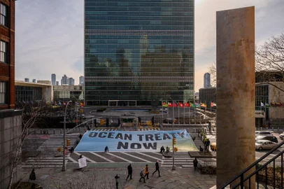 Ativistas com faixa em frente à sede da ONU, durante negociações por tratado de proteção ao alto-mar (Photo by Ed JONES / AFP)<!-- NICAID(15366503) -->