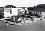 Feira de hortifrutis, banco e pista de patinação em uma mesma esquina nos anos 1950