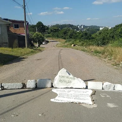 Moradores trancam a Avenida Rachel Caliari Graziotin para chamar a atenção de asfaltamento não concluído no bairro Marini, em Caxias do Sul. <!-- NICAID(15294522) -->