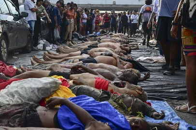 EDITORS NOTE: Graphic content / Bodies are seen lined up on Sao Lucas Square of the Vila Cruzeiro favela at the Penha complex in Rio de Janeiro, Brazil, on October 29, 2025, in the aftermath of Operacao Contencao (Operation Containment). Bodies piled up in poor neighborhoods of Rio de Janeiro on October 28 as police launched their biggest ever raids on the city's drug traffickers, leaving at least 64 dead in war-like scenes. As many as 2,500 heavily armed officers, backed by armored vehicles, helicopters and drones took part in the operation targeting Brazil's main drug-trafficking gang in two poor neighborhoods, or favelas, in northern Rio. (Photo by Pablo PORCIUNCULA / AFP)Editoria: CLJLocal: Rio de JaneiroIndexador: PABLO PORCIUNCULASecao: policeFonte: AFPFotógrafo: STF<!-- NICAID(16156305) -->