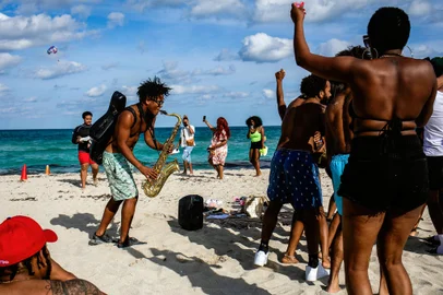 People dance during an impromptu party on South Beach in Miami Beach, Fla., on Wednesday, April 7, 2021. (Scott McIntyre/The New York Times)People dance during an impromptu party on South Beach in Miami Beach, Fla., on Wednesday, April 7, 2021. With vaccinations picking up, warmer weather and increased business reopenings over the last week, tourism has picked up in several popular destinations. (Scott McIntyre/The New York Times)Editoria: TLocal: MIAMI BEACHIndexador: SCOTT MCINTYREFonte: NYTNSFotógrafo: STR<!-- NICAID(14762173) -->
