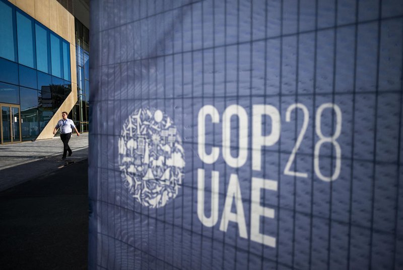 A man walks past a COP28 sign at the venue of the United Nations climate summit in Dubai on November 30, 2023. The UN climate conference opens in Dubai on November 30 with nations under pressure to increase the urgency of action on global warming and wean off fossil fuels, amid intense scrutiny of oil-rich hosts UAE. (Photo by Jewel SAMAD / AFP)Editoria: WEALocal: DubaiIndexador: JEWEL SAMADSecao: diplomacyFonte: AFPFotógrafo: STF<!-- NICAID(15612680) -->