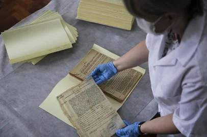 Porto Alegre, RS, Brasil, 07-12-2023: A analista arquivista Laura Arce com páginas da primeira radionovela do Estado, O Solar dos Alvarengas, que completa 80 anos, e faz parte do acervo do Museu da Comunicação Hipólito José da Costa. Reportagem sobre a história das radionovelas do Rio Grande do Sul. Foto: Mateus Bruxel / Agência RBSIndexador: Mateus Bruxel<!-- NICAID(15620365) -->