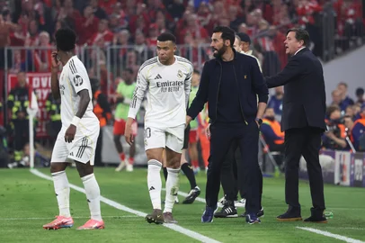 Real Madrid's Spanish coach Alvaro Arbeloa (2nd R) and Real Madrid's French forward #10 Kylian Mbappe (2nd L) are seen on the sidelines during the UEFA Champions League quarter-final second leg football match between FC Bayern Munich and Real Madrid in Munich, southern Germany, on April 15, 2026. (Photo by Karl-Josef HILDENBRAND / AFP)<!-- NICAID(16267146) -->