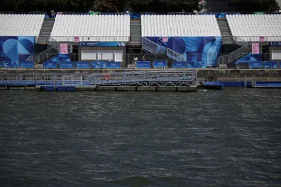 This photograph shows empty stands on the banks of the Seine river, after the first triathlon training session was cancelled during the Paris 2024 Olympic Games in Paris, on July 28, 2024, due to the pollution of the Seine river. The improved weather failed to prevent the first triathlon training session in the River Seine from being cancelled on July 28, 2024. Following a meeting "on the water quality" and tests, "a joint decision was taken to cancel the swimming part of the triathlon orientation," a Paris 2024 and World Triathlon statement said. (Photo by Valentine CHAPUIS / AFP)<!-- NICAID(15827925) -->
