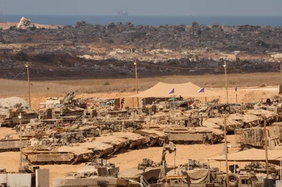 Israeli soldiers conduct maintenance work on their armoured vehicles at a position along the Israel-Gaza border fence on October 10, 2025. Gaza's civil defence agency said on October 10 that Israeli forces have begun pulling back from parts of the territory, particularly in Gaza City and Khan Yunis. Israeli prime minister's office said that the government had "approved the framework" of a hostage release deal with Hamas, as both sides edged closer to ending more than two years of hostilities in Gaza. (Photo by Jack GUEZ / AFP)<!-- NICAID(16143273) -->