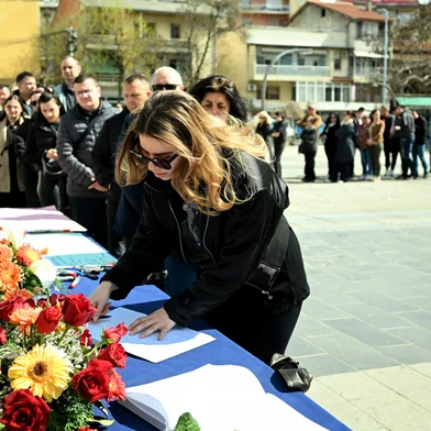 A woman signs a book of condolences in Kocani on March 17, 2025, a day after a fire tore through an overcrowded nightclub packed with mostly young people in North Macedonia killing 59 revellers. A fire tore through an overcrowded nightclub packed with mostly young people in North Macedonia early on March 16, 2025, killing 59 people, apparently after on-stage fireworks at a hip-hop concert set the venue ablaze, authorities said. Some 155 people who were injured in the inferno had been taken to hospitals across the country, 22 of them in critical condition, officials said. (Photo by Robert ATANASOVSKI / AFP)<!-- NICAID(15997113) -->