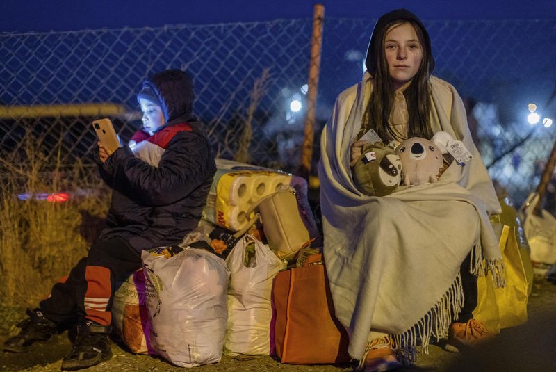 TOPSHOT - Helena (R) and her brother Bodia (L) from Lviv are seen at the Medyka pedestrian border crossing, in eastern Poland on February 26, 2022, following the Russian invasion of Ukraine. - Ignoring warnings from the West, Russian President Vladimir Putin unleashed a full-scale invasion of Ukraine that the UN refugee agency said has forced almost 116,000 people to flee to neighbouring countries. (Photo by Wojtek RADWANSKI / AFP)<!-- NICAID(15028507) -->
