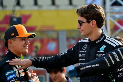 ANDREJ ISAKOVIC / AFP McLaren's British driver Lando Norris and Mercedes' British driver George Russell chat ahead of the Abu Dhabi Formula One Grand Prix at the Yas Marina Circuit in Abu Dhabi on December 7, 2025. (Photo by Andrej ISAKOVIC / AFP)<!-- NICAID(16182486) -->