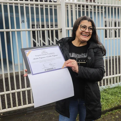 CAXIAS DO SUL, RS, BRASIL. 08-08-2025. Presidente da Amob do loteamento Vitória, Genesio de Jesus santo, fala da importância da regularização fundiária pra comunidade. Na foto, a dona de casa Marilei de Camargo Cagnini, que recebeu o documento em dezembro de 2022.Indexador: Bruno Todeschini<!-- NICAID(16097587) -->