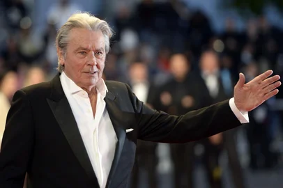 (FILES) This file photo taken on May 25, 2013 shows French actor Alain Delon arriving to attend the screening of the new restored version of the film "Plein Soleil" presented in Cannes Classics at the 66th edition of the Cannes Film Festival in Cannes.=Delon, the French star dubbed one of "the best looking actors of all time", declared on May 9, 2017 that he was calling time on his career. The 81-year-old screen legend -- who is credited with inventing the character of the cerebral hitman, which has since become a Hollywood standard -- told AFP that he would do one last film and a play before retiring. / AFP PHOTO / ANNE-CHRISTINE POUJOULAT<!-- NICAID(12902989) -->