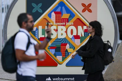 Visitors pass by a web summit logo during the Web Summit at Parque das Nacoes in Lisbon, on November 11, 2025. The Web summit, the annual gathering of the digital economy and new technologies, will take place from November 10 to 14. (Photo by PATRICIA DE MELO MOREIRA / AFP)<!-- NICAID(16165603) -->