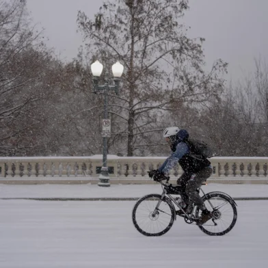 HOUSTON, TEXAS - JANUARY 21: A man bikes along Sabine Street Bridge near downtown as winter storm Enzo brings heavy bands of snow and sleet on January 21, 2025 in Houston, Texas. Houston and the surrounding areas are predicted to receive three to six inches of snow, according to The National Weather Service.   Danielle Villasana/Getty Images/AFP (Photo by Danielle Villasana / GETTY IMAGES NORTH AMERICA / Getty Images via AFP)<!-- NICAID(15958726) -->