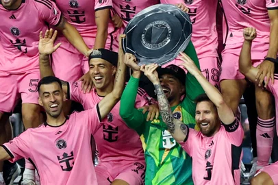 Inter Miami's Spanish midfielder #05 Sergio Busquets, Uruguayan forward #09 Luis Suarez, US goalkeeper #01 Drake Callender and Argentine forward #10 Lionel Messi hold the Supporters' Shield after the Major League Soccer (MLS) football match against New England Revolution at Chase Stadium in Fort Lauderdale, Florida, October 19, 2024. (Photo by Chris Arjoon / AFP)<!-- NICAID(15894605) -->