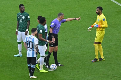 Slovenian referee Slavko Vincic speaks with Saudi Arabia's goalkeeper #21 Mohammed Al-Owais during the Qatar 2022 World Cup Group C football match between Argentina and Saudi Arabia at the Lusail Stadium in Lusail, north of Doha on November 22, 2022. (Photo by Glyn KIRK / AFP)Editoria: SPOLocal: DohaIndexador: GLYN KIRKSecao: soccerFonte: AFPFotógrafo: STR<!-- NICAID(15272199) -->